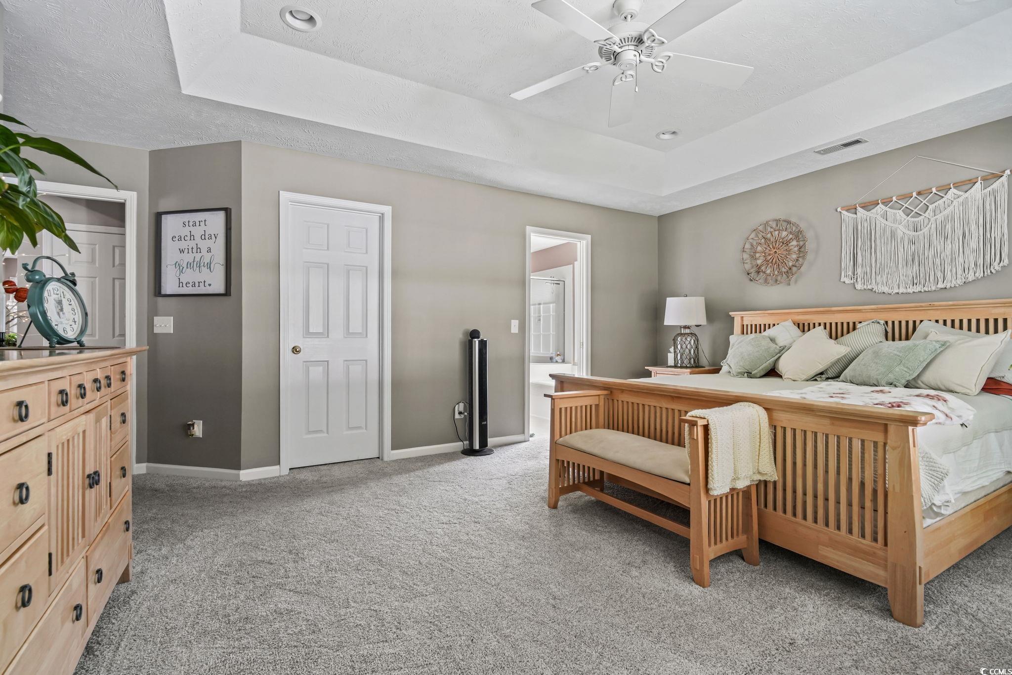 4105 Eva Bay Drive Murrells Inlet, SC 29576 - Photo 22 of 40 Bedroom with a raised ceiling, light colored carpet, ceiling fan, and connected bathroom
