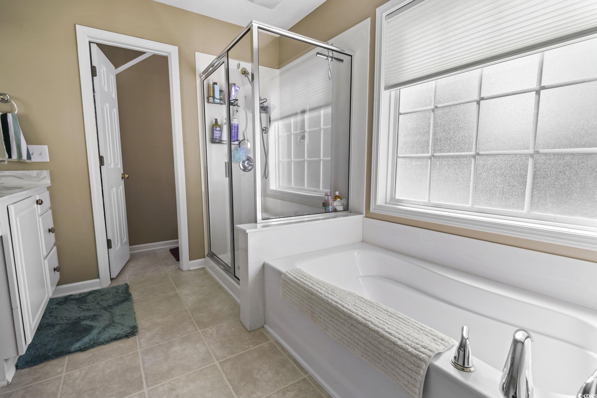 4105 Eva Bay Drive Murrells Inlet, SC 29576 - Photo 24 of 40 Bathroom with light tile patterned floors, a garden tub, vanity, and a shower stall