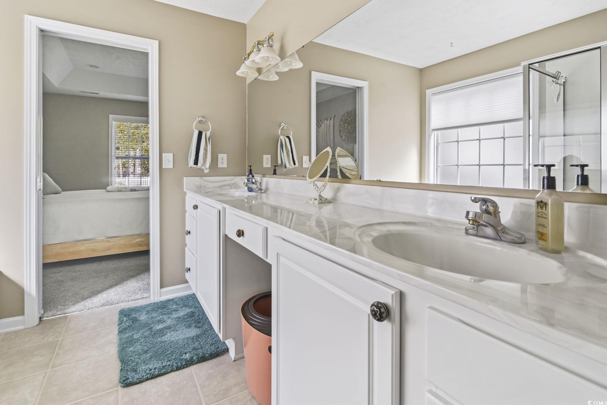 4105 Eva Bay Drive Murrells Inlet, SC 29576 - Photo 25 of 40 Ensuite bathroom with double vanity, light tile patterned floors, and a stall shower