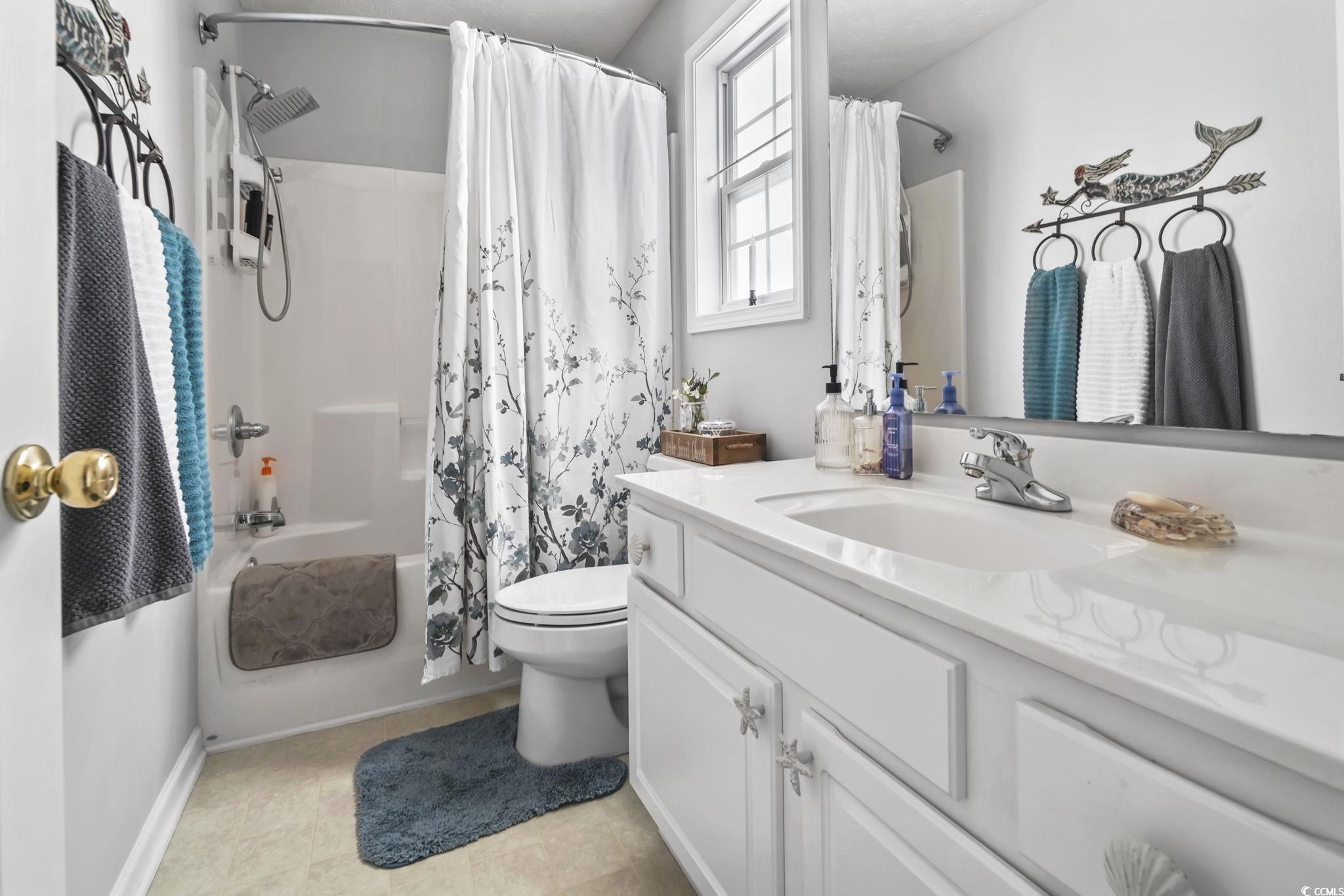 4105 Eva Bay Drive Murrells Inlet, SC 29576 - Photo 30 of 40 Bathroom featuring shower / bathtub combination with curtain, vanity, and light tile patterned floors