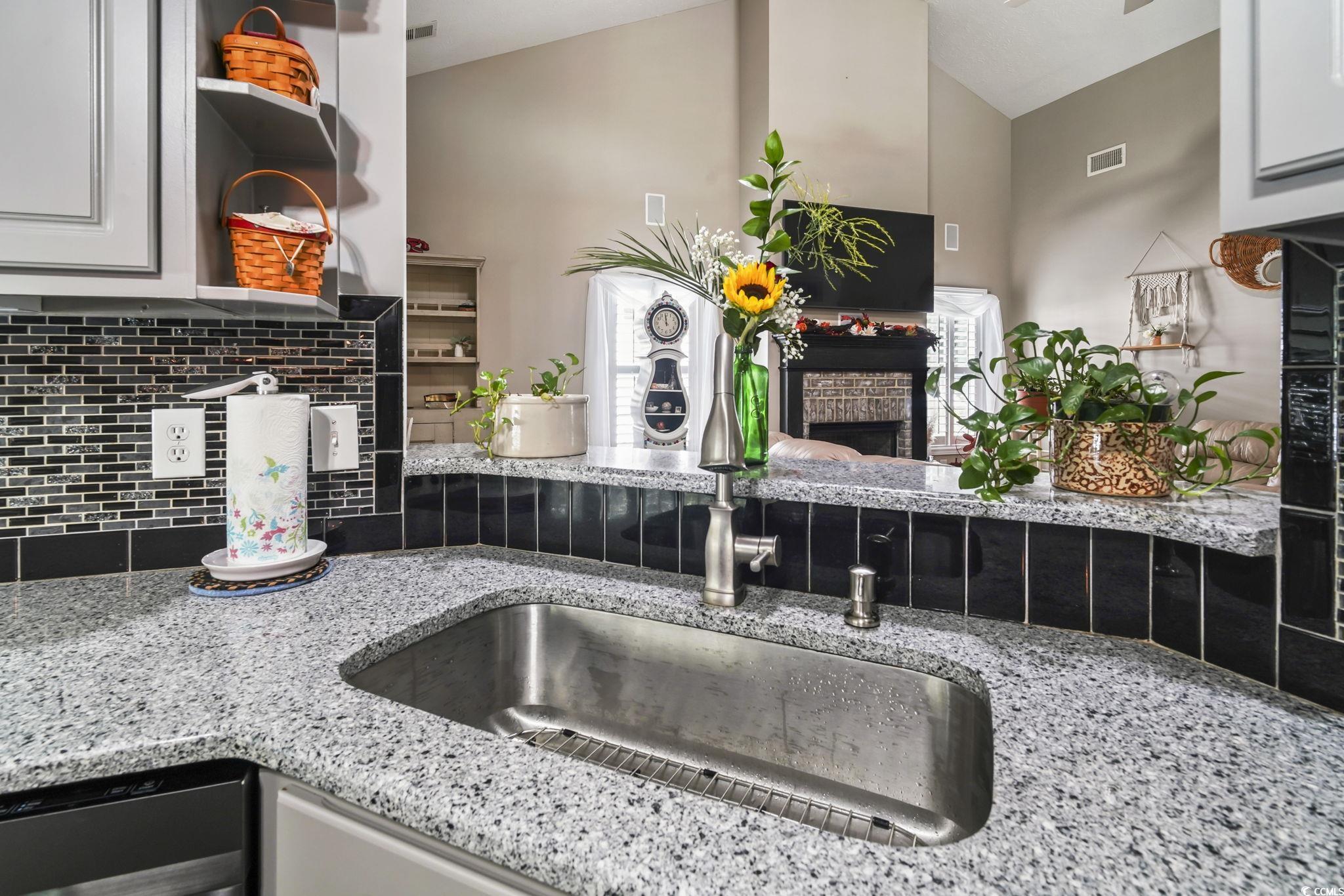 4105 Eva Bay Drive Murrells Inlet, SC 29576 - Photo 7 of 40 Kitchen view of open shelves, light stone counters, a fireplace, and backsplash