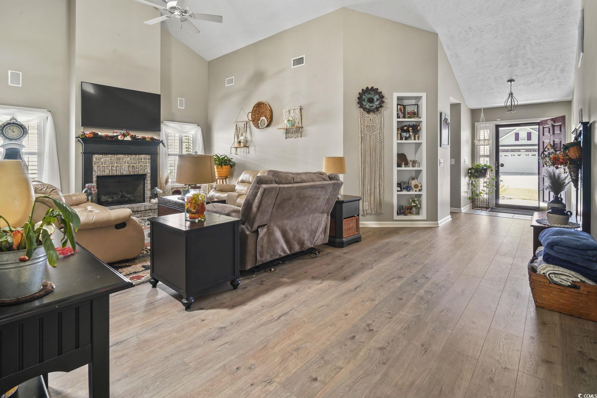 4105 Eva Bay Drive Murrells Inlet, SC 29576 - Photo 9 of 40 Living area with high vaulted ceiling, light wood-style flooring, a stone fireplace, and ceiling fan