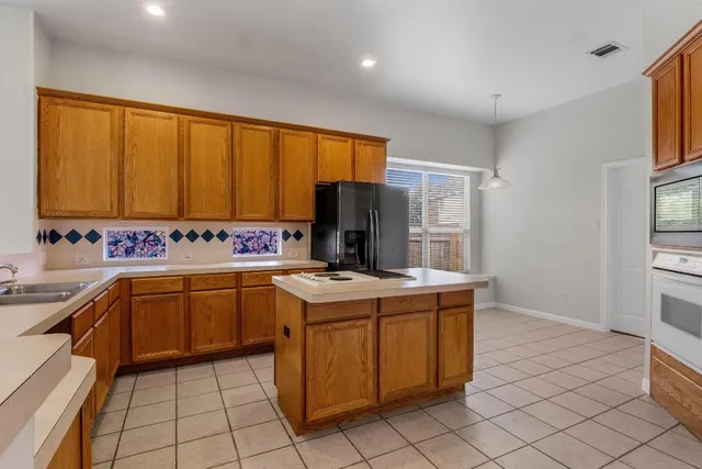 a kitchen with a stove top oven sink and cabinets