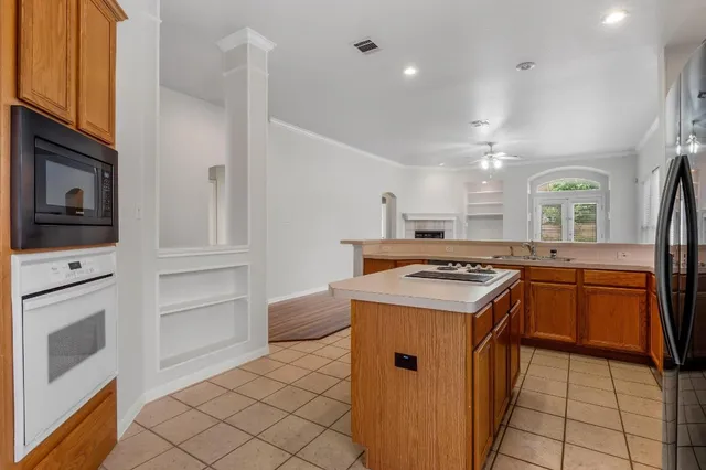 a kitchen with kitchen island granite countertop a stove and a sink