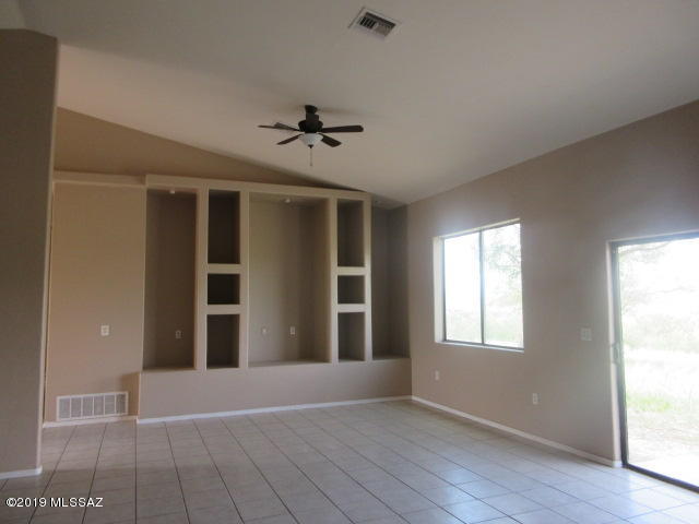 965 Circulo Tumbleweed Rio Rico, AZ 85648 - Photo 7 of 18 a view of an empty room with a window and wooden floor