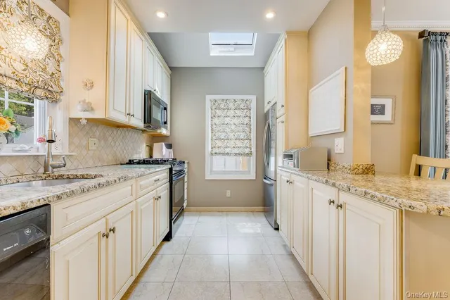 a kitchen with granite countertop a sink stove and cabinets