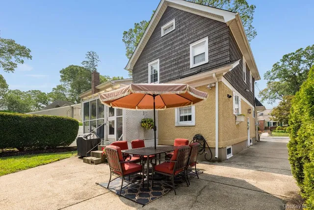 a patio with a table and chairs under an umbrella