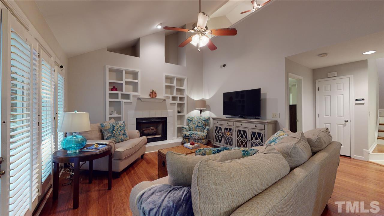 3827 Carnegie Lane Raleigh, NC 27612 - Photo 11 of 30 a living room with furniture a flat screen tv and a fireplace