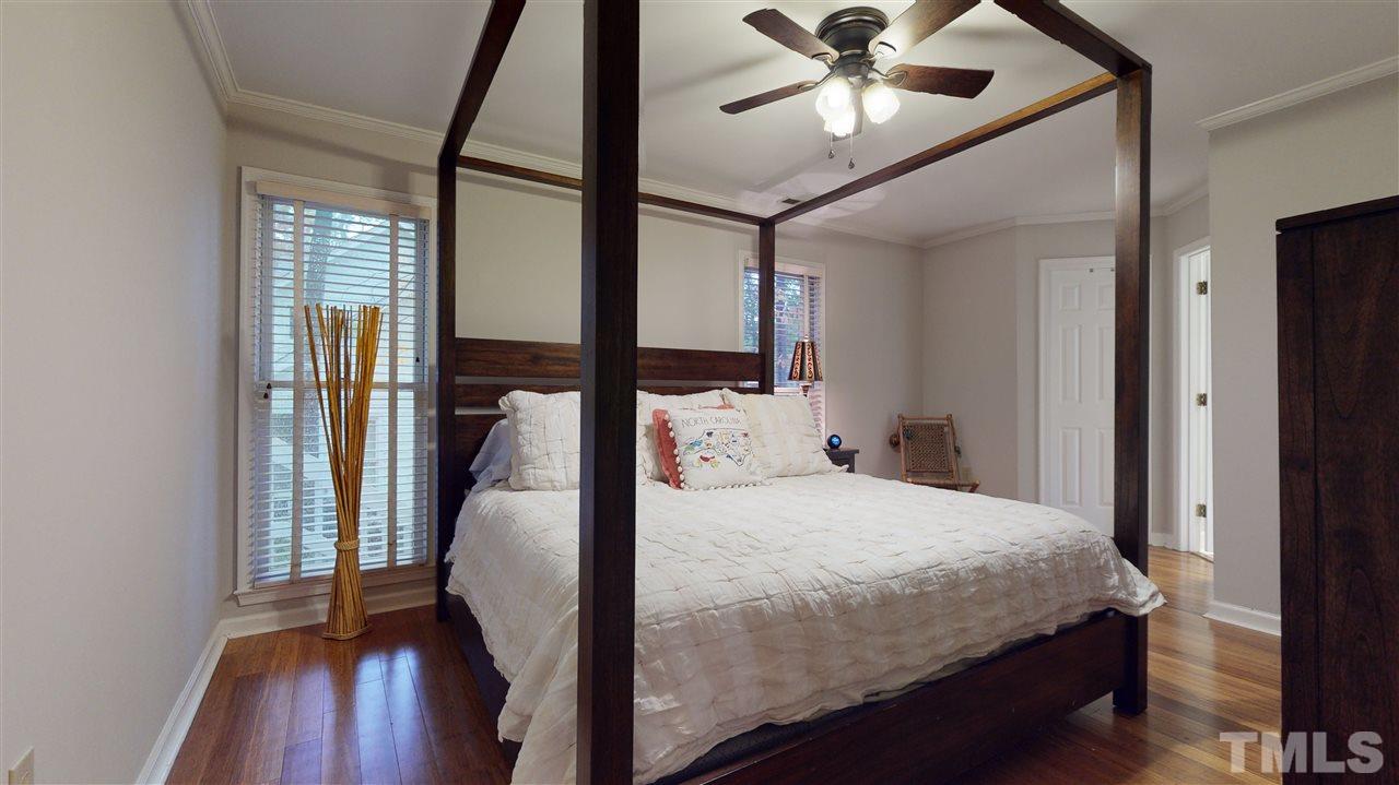 3827 Carnegie Lane Raleigh, NC 27612 - Photo 15 of 30 a bedroom with a bed and wooden floor