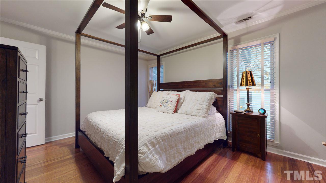 3827 Carnegie Lane Raleigh, NC 27612 - Photo 17 of 30 a bedroom with a bed and wooden floor