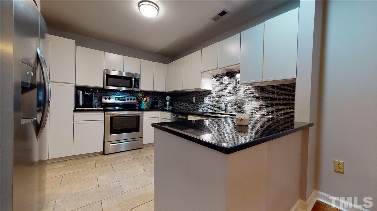 3827 Carnegie Lane Raleigh, NC 27612 - Photo 3 of 30 a kitchen with stainless steel appliances granite countertop a sink stove and refrigerator