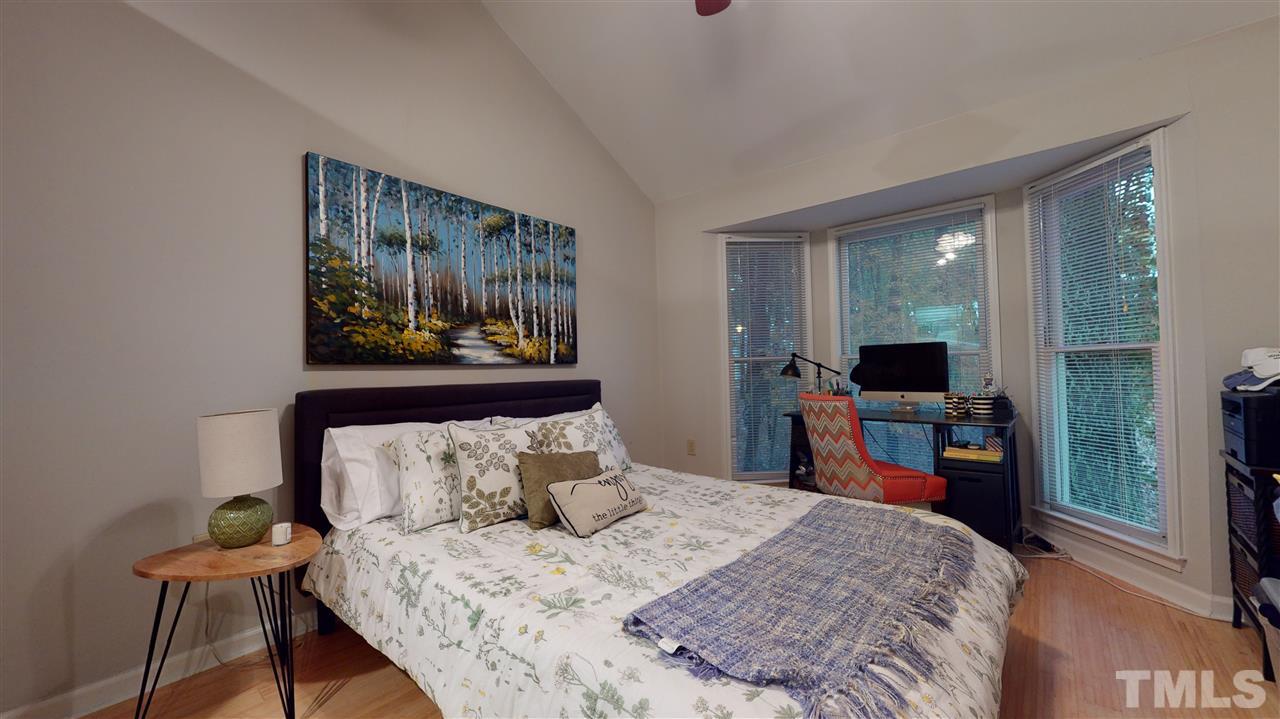 3827 Carnegie Lane Raleigh, NC 27612 - Photo 24 of 30 a bedroom with a bed and a flat tv screen on the dresser