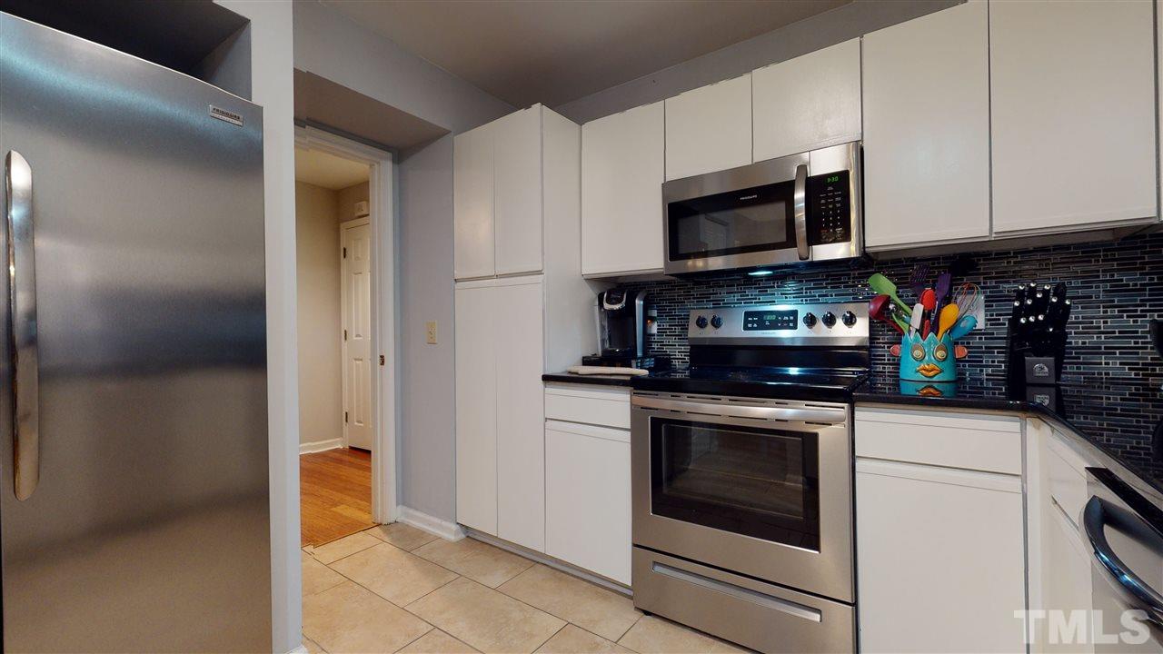 3827 Carnegie Lane Raleigh, NC 27612 - Photo 6 of 30 a kitchen with stainless steel appliances granite countertop a stove a microwave and a refrigerator
