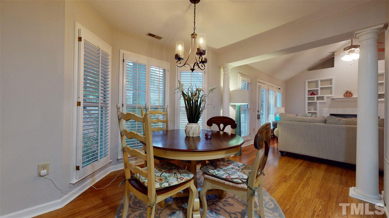 3827 Carnegie Lane Raleigh, NC 27612 - Photo 8 of 30 a dining room with furniture a chandelier and wooden floor