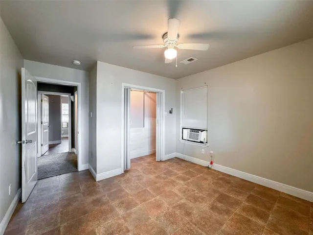 an empty room with fan and windows