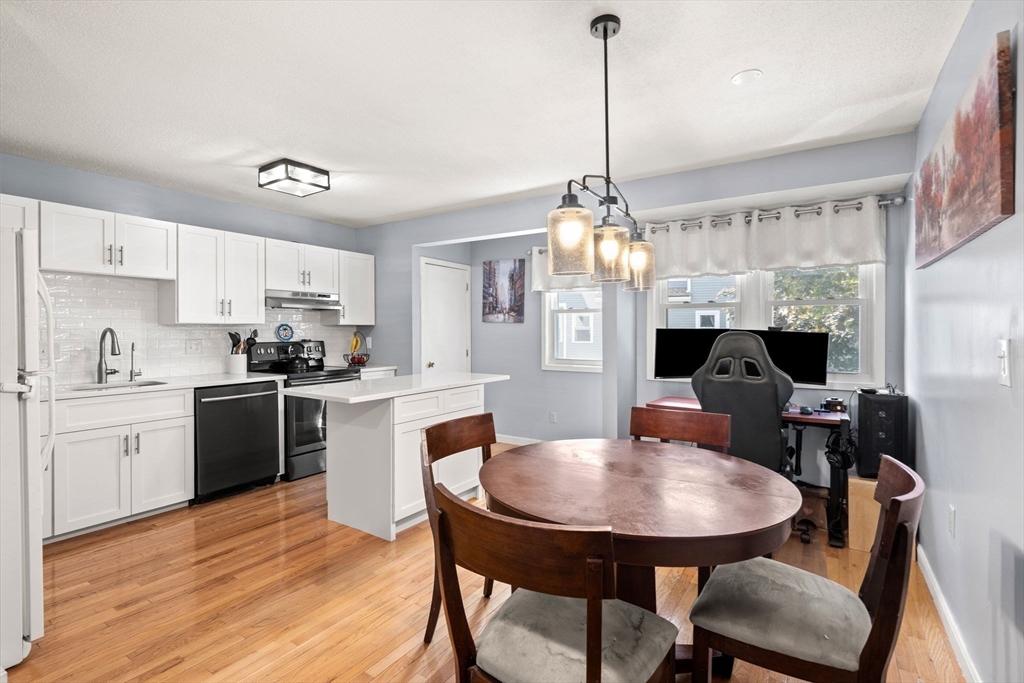 2 Halsey Way, Unit 40C Salem, MA 01970 - Photo 5 of 19 a kitchen with stainless steel appliances kitchen island granite countertop a dining table chairs and white cabinets