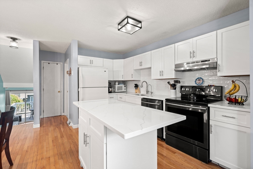 2 Halsey Way, Unit 40C Salem, MA 01970 - Photo 6 of 19 a kitchen with a sink a stove a refrigerator and white cabinets