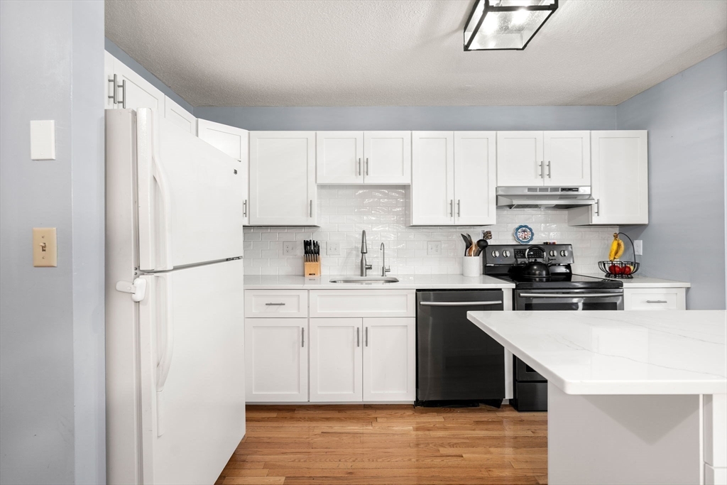 2 Halsey Way, Unit 40C Salem, MA 01970 - Photo 7 of 19 a kitchen with a white cabinets and refrigerator