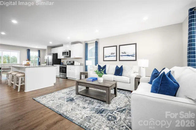 a living room with furniture and view of kitchen