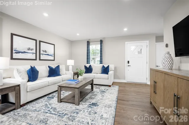a living room with furniture a flat screen tv and a window