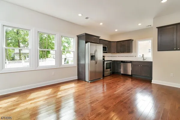 a view of kitchen with wooden floor and electronic appliances