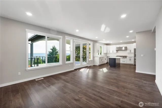 a view of empty room with wooden floor and windows