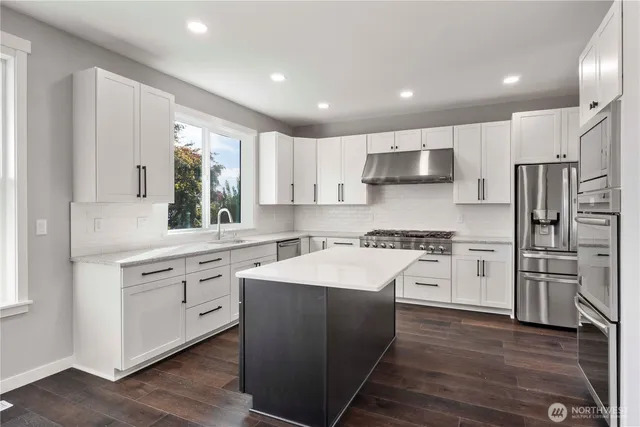 a kitchen with white cabinets and stainless steel appliances