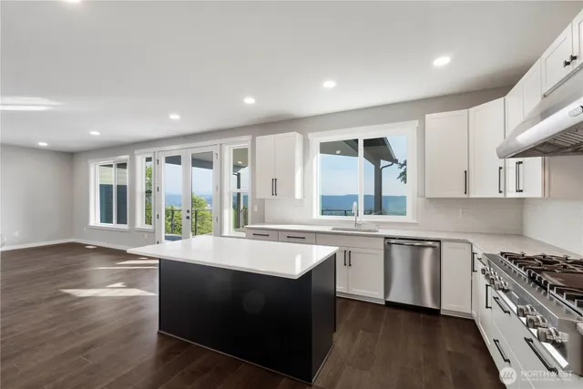 a large kitchen with granite countertop a stove and a sink