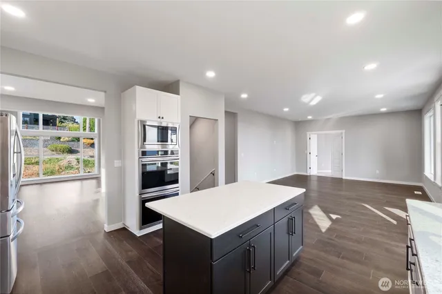 a kitchen that has a lot of cabinets a sink and wooden floor