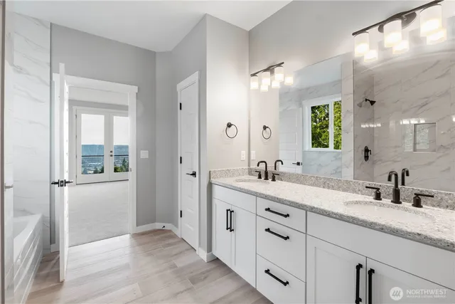 a bathroom with a double vanity sink and mirror with shower