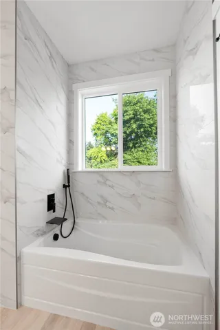 a bathroom with a bathtub and window