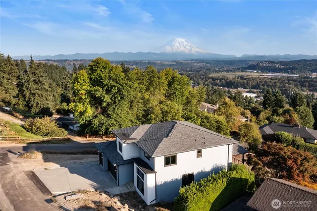 an aerial view of a house with yard and mountain view in back