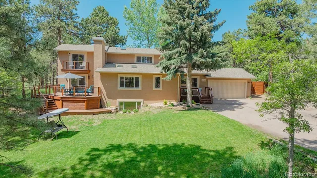 a front view of a house with a yard and trees