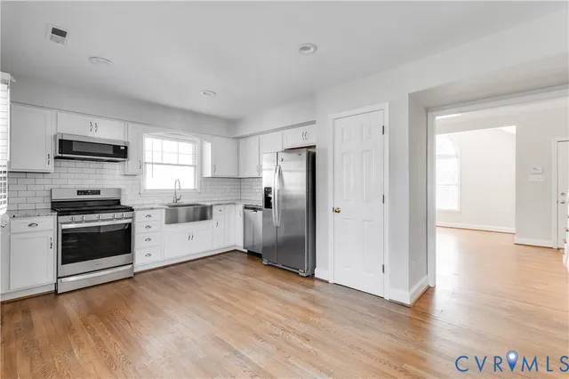 a kitchen with stainless steel appliances a refrigerator and a stove top oven