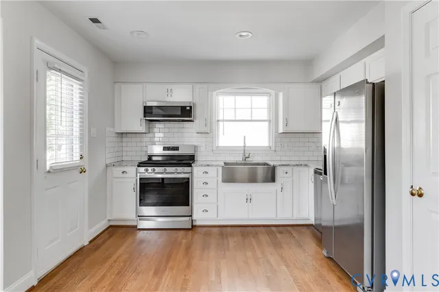 a kitchen with a refrigerator and a stove top oven