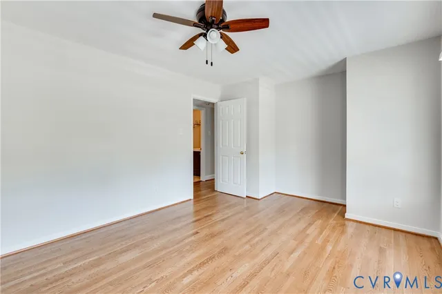 a view of a room with wooden floor and ceiling fan