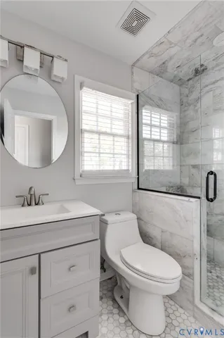 a bathroom with a toilet sink a mirror and vanity