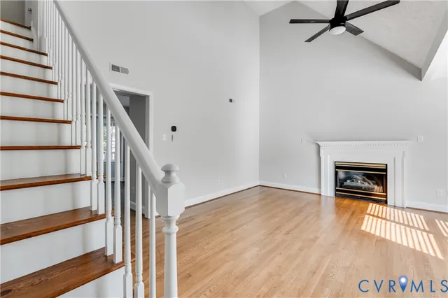 a view of a hallway with wooden floor and staircase