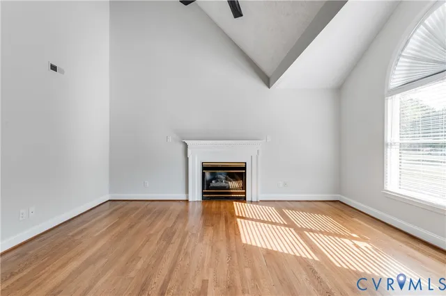 wooden floor fireplace and windows in an empty room