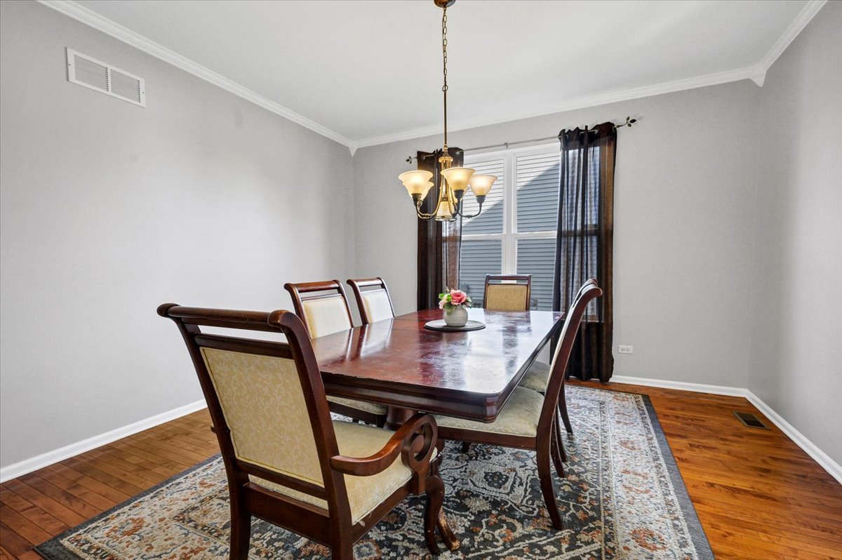 322 Zinnia Drive Romeoville, IL 60446 - Photo 5 of 42 a dining room with furniture a chandelier and wooden floor