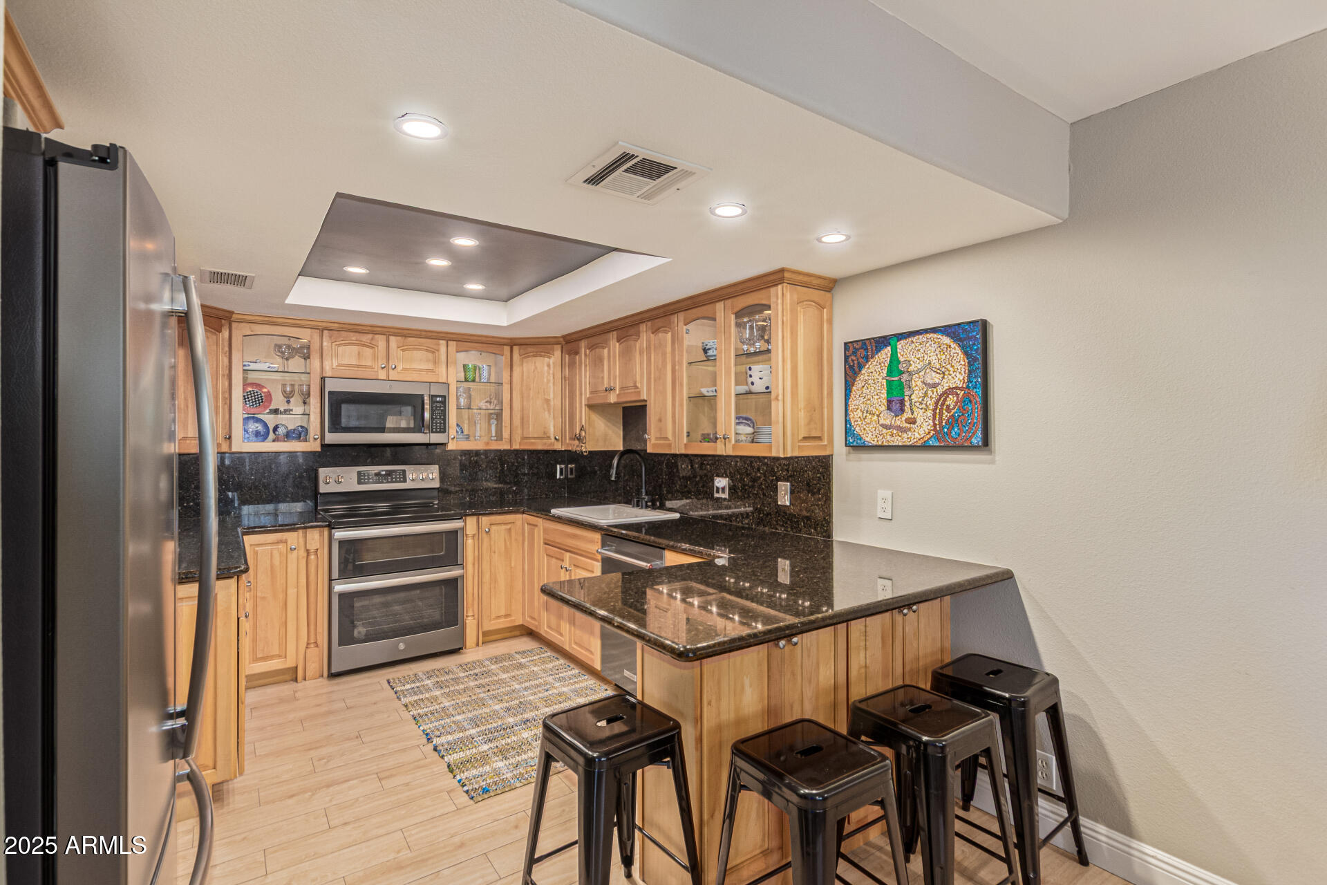 7940 East Camelback Road, Unit 605 Scottsdale, AZ 85251 - Photo 15 of 35 a kitchen with stainless steel appliances granite countertop a refrigerator and a stove top oven