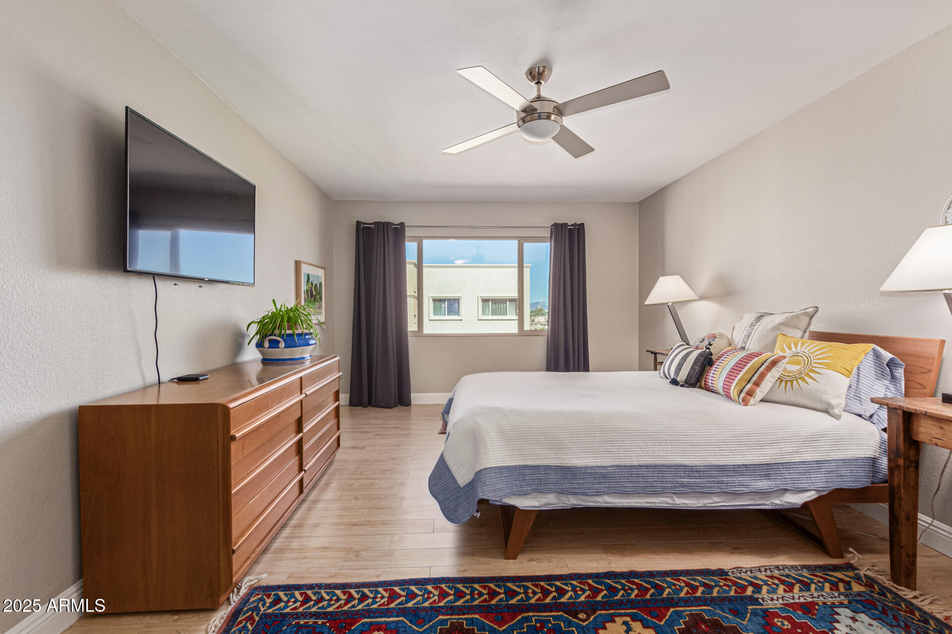 7940 East Camelback Road, Unit 605 Scottsdale, AZ 85251 - Photo 17 of 35 a bedroom with a bed window and a flat tv screen on dresser