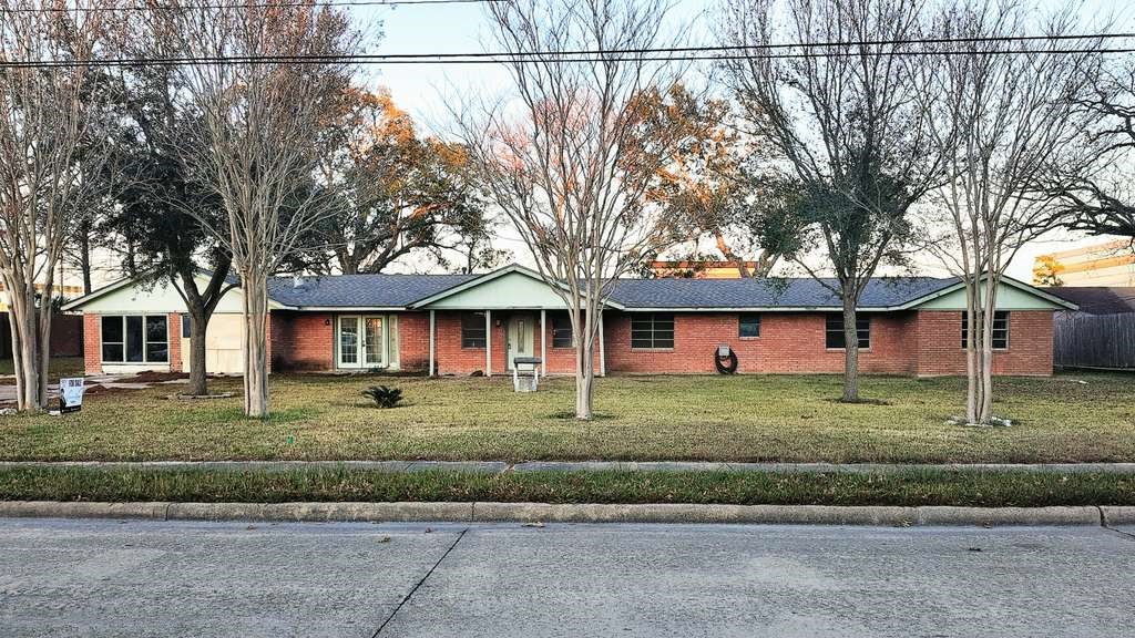 18219 Kings Lynn Street Webster, TX 77058 - Photo 3 of 6 a view of a big house with a big yard and large trees