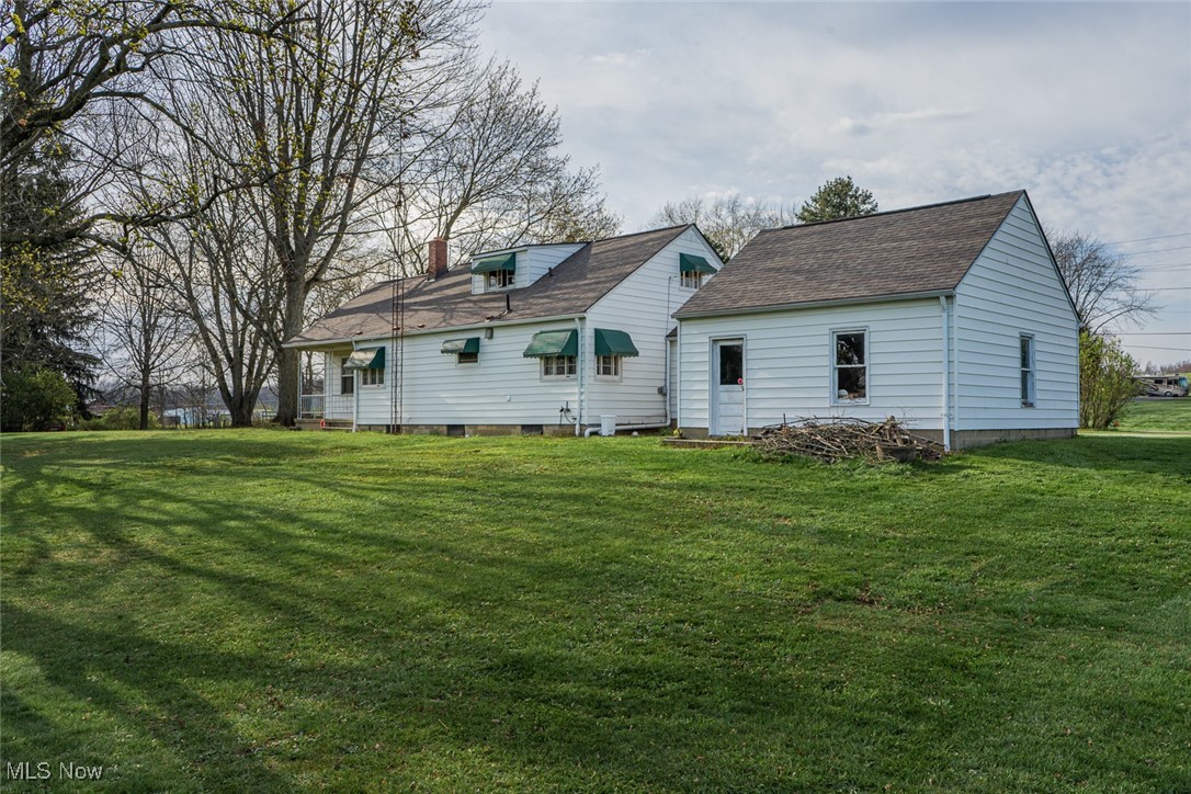 3356 Waterloo Road Mogadore, OH 44260 - Photo 2 of 24 Rear view of house featuring a lawn and a chimney