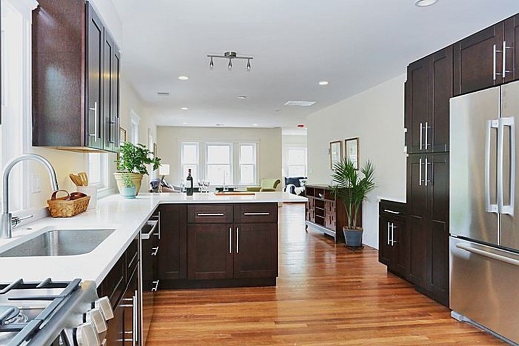 a large kitchen with stainless steel appliances granite countertop a sink refrigerator and cabinets