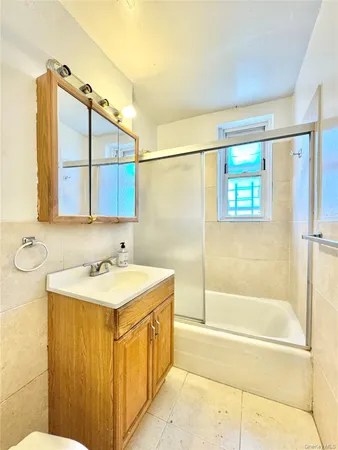 a bathroom with a tub a sink and a mirror