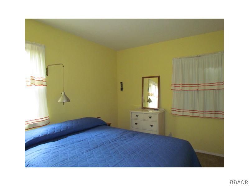 21 Holcomb Valley Road Big Bear Lake, CA 92315 - Photo 9 of 25 a bedroom with a bed and wooden floor