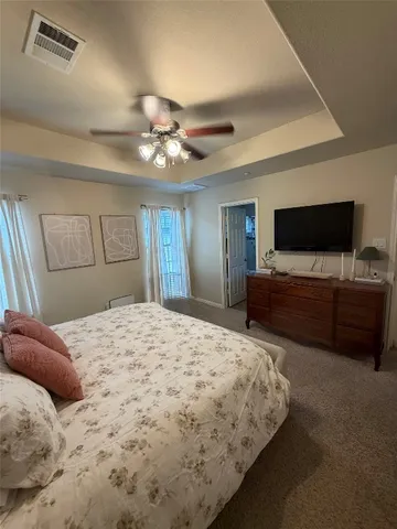 a bedroom with a large bed and a flat tv screen