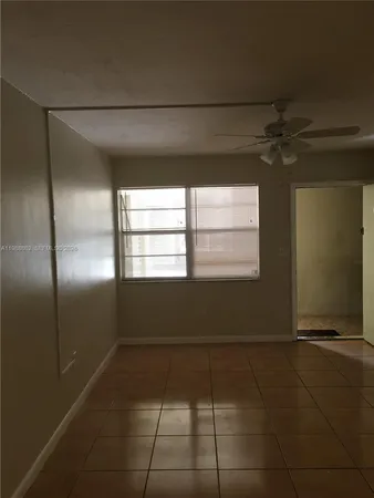 a room with a window and a refrigerator