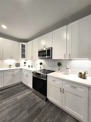 a kitchen with sink a microwave and cabinets